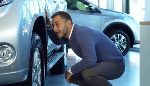 Sotto auto uomo guarda